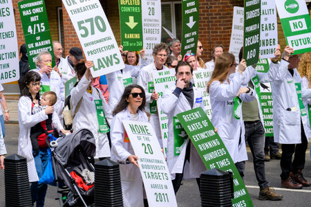 LONDON - April 22, 2023: Medical community at the forefront: Doctors carrying signs at the Extinction Rebellion protest march in London.のeditorial素材