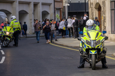 LONDON - April 22, 2023: Police motorcycles maintain order at the Extinction Rebellion protest march in London, ensuring a safe environment for climate activists.のeditorial素材