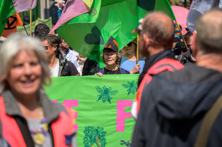 LONDON - April 22, 2023: Age no barrier: An older woman passionately joins the Extinction Rebellion protest rally in London, symbolizing that climate activism transcends generations.のeditorial素材