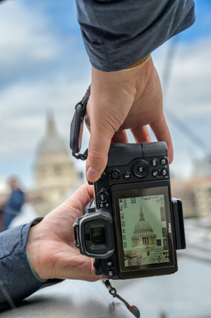 LONDON - April 24, 2023: A close-up of hands holding a camera, capturing a unique view of St Paul's...
