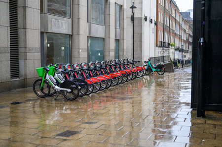 LONDON - April 24, 2023: Rainy weather won't stop urban exploration with rental bikes near Charing Cross railway station, part of London's cycling revolution.のeditorial素材