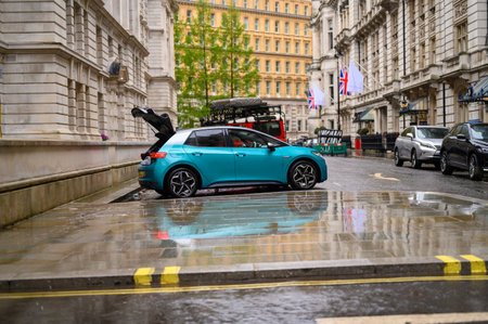 LONDON - April 24, 2023: A car with its boot open, reflected in wet pavement on the back streets of...