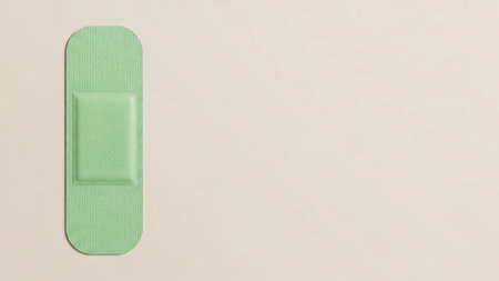 A single green adhesive bandage is shown against a neutral, light-colored background, emphasizing its simplicity and color.の写真素材