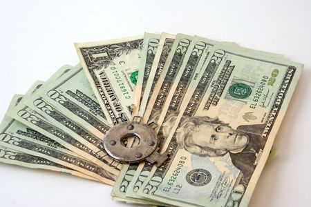 A picture of an automotive spark plug-gapping tool on currency.  Representing the measurement of income, budgets, sales or money in business.の写真素材