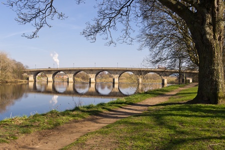 Hexham Bridge and riverside path from upstream framed by trees