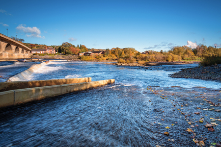 River Tyne flows over Hexham Weir, with its new Fish Pass below the bridge, which will help returning salmon migrate up the River Tyneの写真素材