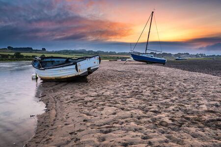 Boats on the Aln Estuary at Sunset, as the River Aln approaches the North Sea at Alnmouth, now tidal, there are several boats moored in the estuaryの写真素材