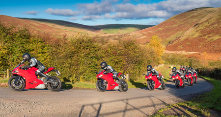 Red Motorbike Progression, in an action sequence on a country road in Upper Coquetdale, Northumberlandの写真素材