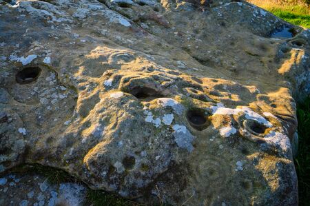 Close-up of Lordenshaws Hillfort Rock Art, located near Rothbury in Northumberland National Park and has several large stones with prehistoric rock art also known as Cup and Ring Marksの写真素材