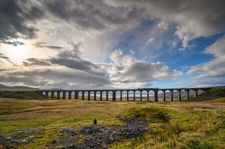 Train on Ribblehead Viaduct, which carries the Settle to Carlisle Railway across Batty Moss spanning 400 m and 32 m above the valley floorの写真素材