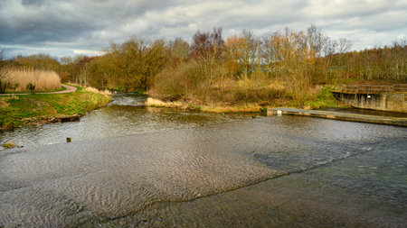 River Derwent downstream of Weir and Fish Pass, formed by the meeting of two burns and flows between...