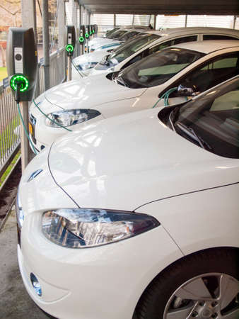 electric vehicles being recharged at a row of charging stationsのeditorial素材