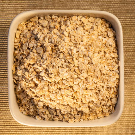 porridge oats,  a low glycemic index food, in a square bowl, viewed from aboveの写真素材