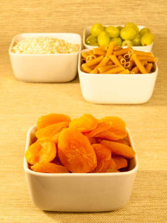 dried apricots a low glycemic index food in a bowl with a selection of other low glycemic foods in the backgroundの写真素材