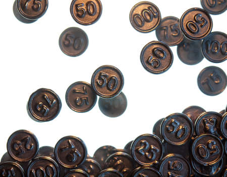 black liquorice coins falling against a white background  Selective focus with coins in foreground...