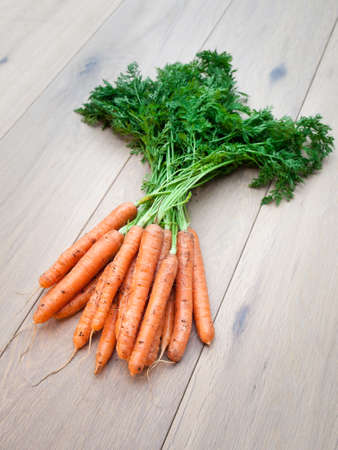 Freshly harvested carrots on aged wooden backgroundの写真素材