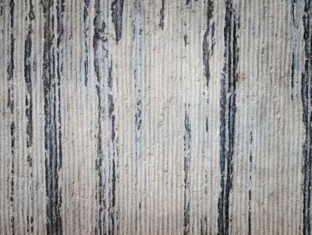 detail of roughly ridged aging grey stone masonry with dark weathered streeksの写真素材