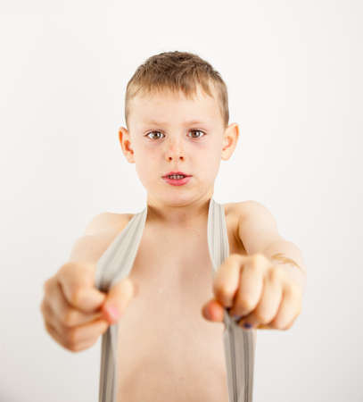 portrait of a small boy looking tough wearing braces over a bare chest の写真素材