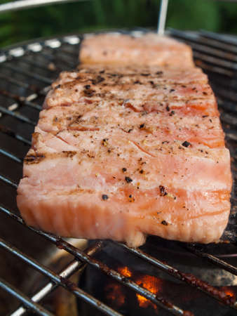 salmon steak  cooking on a barbecue  in a gardenの写真素材
