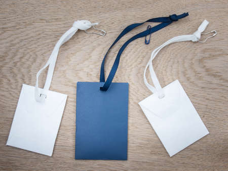blue and white paper envelopes with blue and white ribbon sand safety pins against an aged grained oak wood backgroundの写真素材