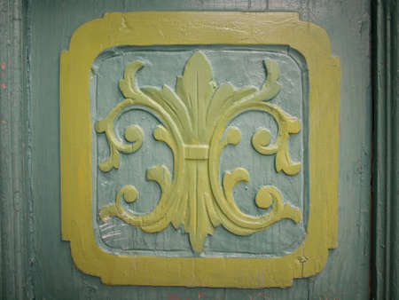 carved leaf motif on a rustic green painted wooden doorの写真素材