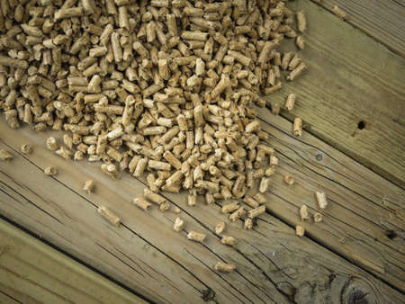 overhead view of wood pellets against an aged knotted wooden backround