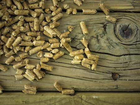 overhead view of wood pellets against an aged knotted wooden backround