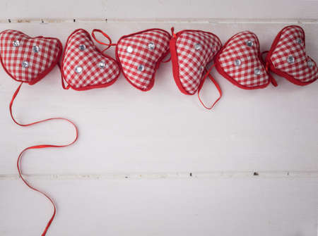 red check hearts  with red ribbon on rustic white wooden backgroundの写真素材