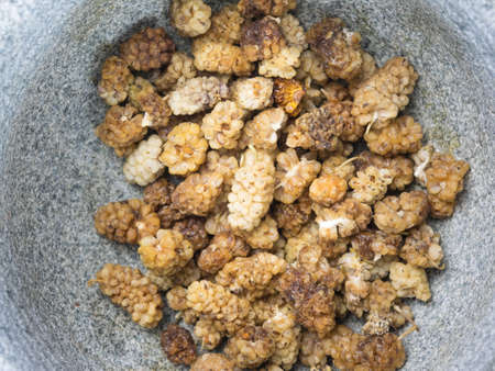closeup of dried mulberries in a stone bowlの写真素材