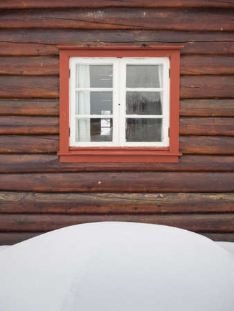 detail of  wooden cabin with snowdrift in foreground