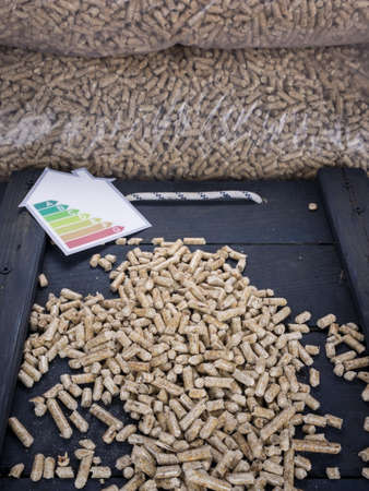 wood pellets on a trap door with sacks of wood pellets and an energy lable behindの写真素材