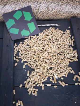 wood pellets in a wood pellet store with recycling symol behindの写真素材