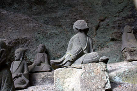 A bodhisattva statue stands on the side of Mt. Nokogiri, a sacred temple mountain in Chiba, Japan.  Thousands of these statues stand on the mountainside.のeditorial素材