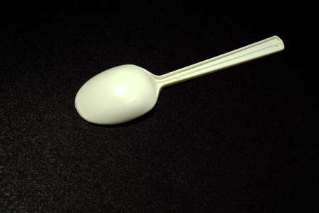 Close up still life of a simple plastic spoon.  Part of a continuing series of experimenting with improvised lighting and close-up shotsの写真素材