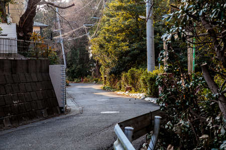 a road winds across a hilltop in Fujisawa, Japan.の写真素材