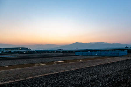 The sun sets behind the mountains in a farming area near Ebina, Japanの写真素材
