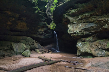 Summer day closeup of a small waterfall flowing into a dark, rocky ravine at Hocking Hills State Park in Hocking County, Ohio.の写真素材