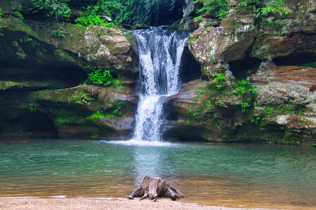 Summer day closeup of a waterfall flowing into a small pool in a lush ravine at Hocking Hills State Park in Hocking County, Ohio.の写真素材