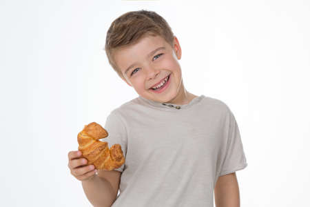 kid holds a fresh croissantの写真素材