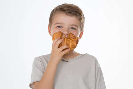 kid smiles while showing a croissantの写真素材