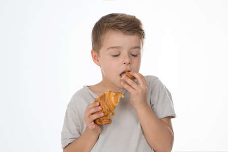 kid tastes a piece of croissantの写真素材