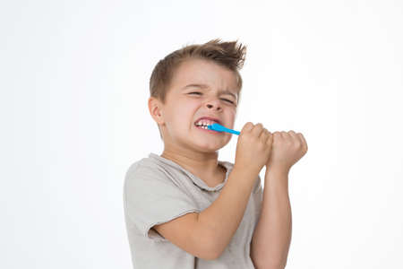 kid holds and bites his toothbrushの写真素材
