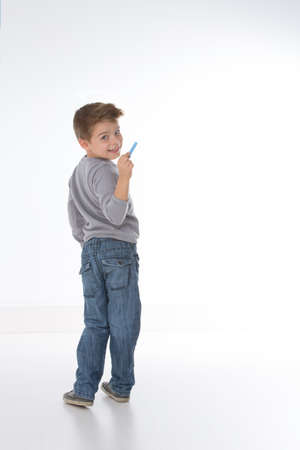 little kid intends to write something on empty wallの写真素材