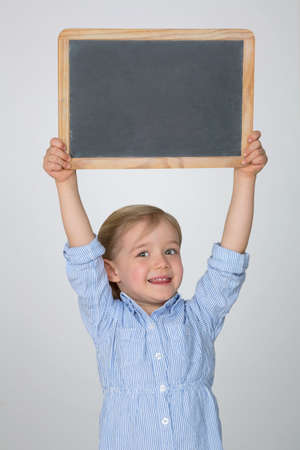 little child exhibits empty blackboardの写真素材