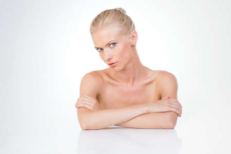 blond determined girl seated with crossed arms