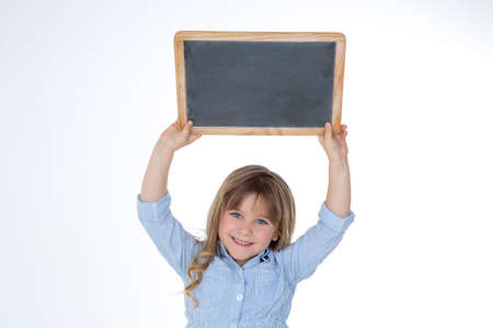 little kid lifts empty blackboard over her headの写真素材