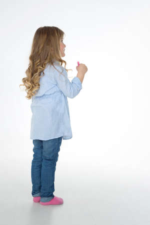 blond girl thinking about her drawingの写真素材