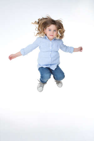 child jumps high on white and isolated backgroundの写真素材