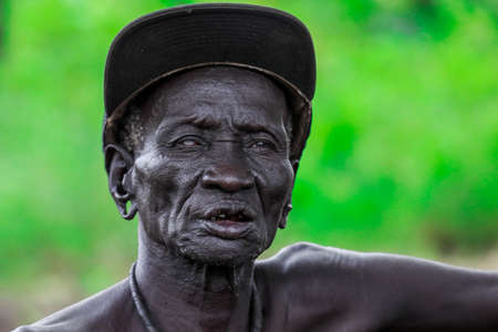 Omo River Valley, Ethiopia - November 29, 2020: Portrait of Blind African Old Man siting on the...