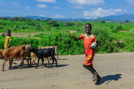 Jinka region, Ethiopia - November 30, 2020: Portrait of Young Shepherd of Cows in the Omo River...